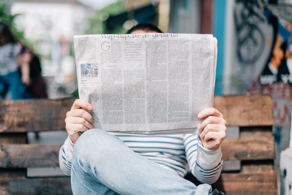 Person reading a broadsheet newspaper